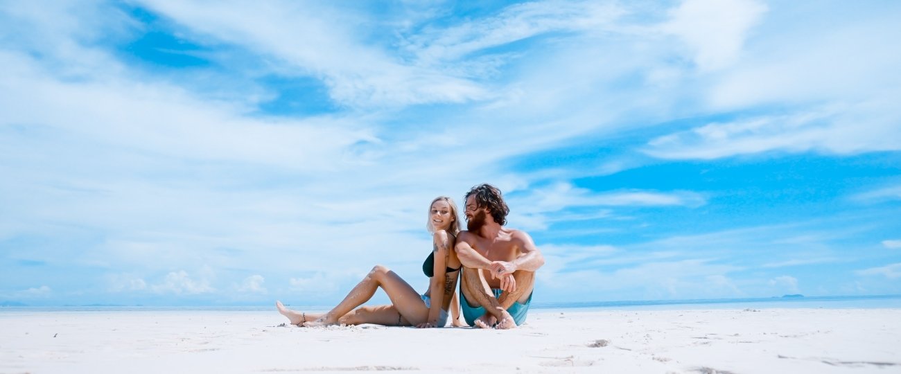 toa-heftiba-dti56waifB4-unsplash.jpg Couple sitting on beach