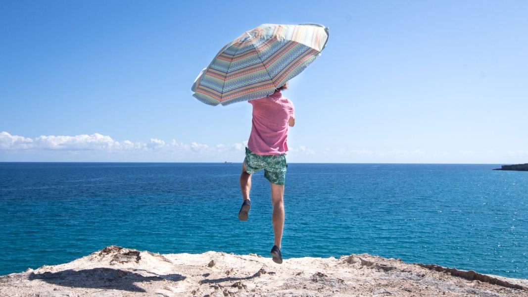 Man with umbrella, overlooking Bari coast