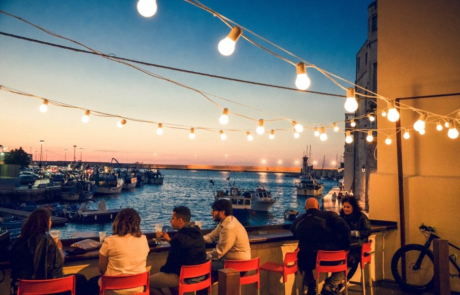 Diners in outdoor cafe, overlooking the Bari coast